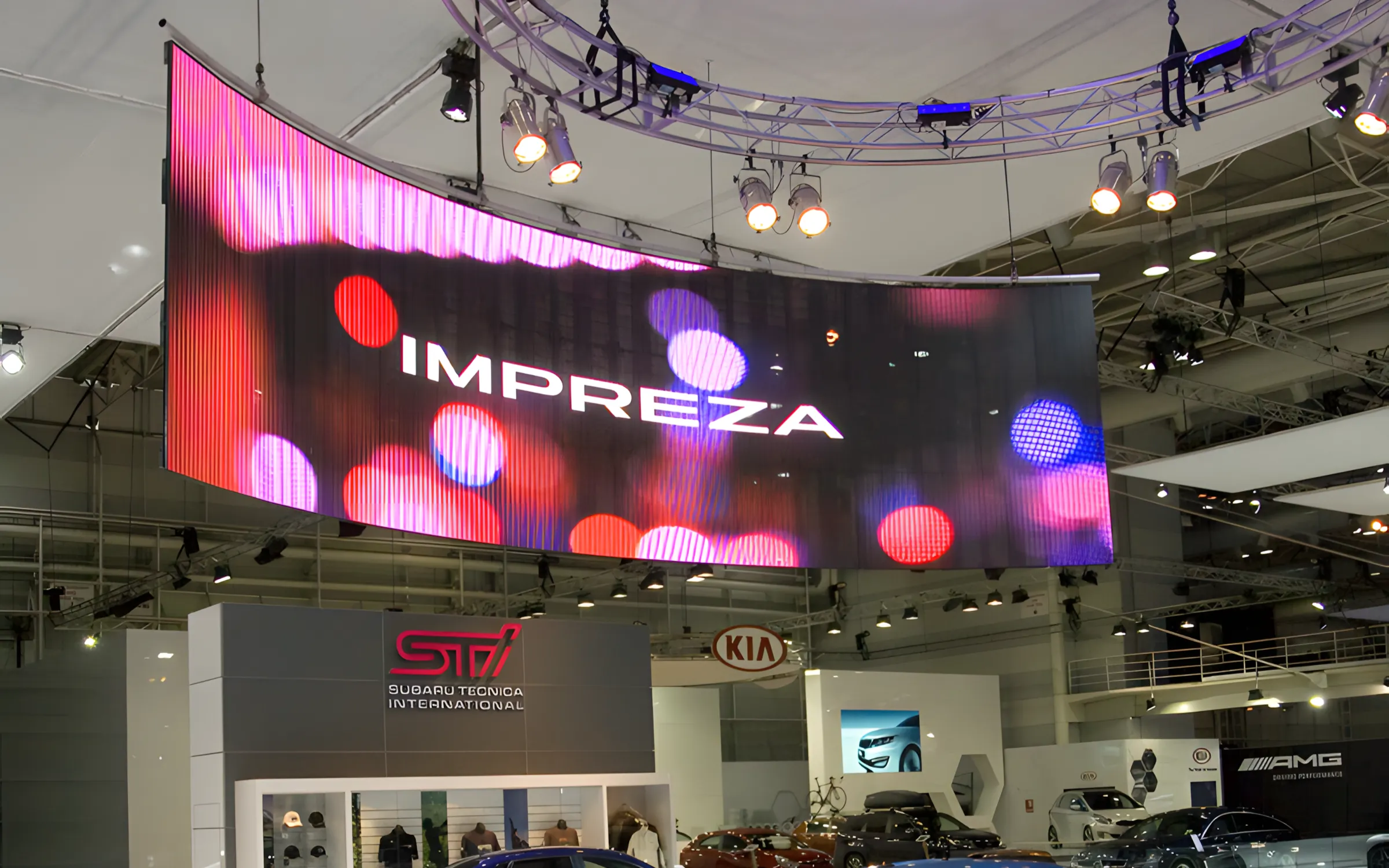 Curved transparent LED display suspended above an automotive exhibition booth