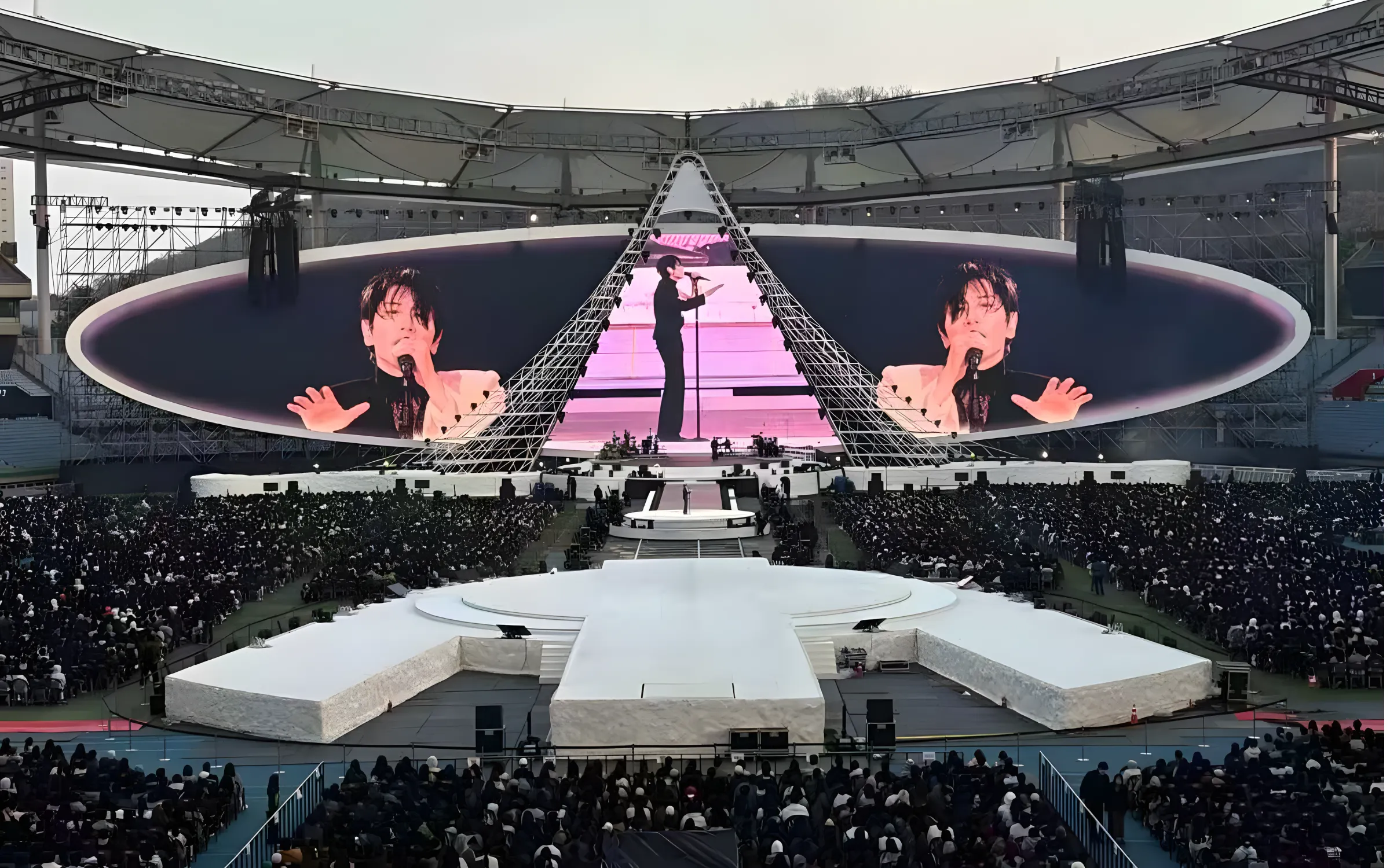 Large curved LED stage screen at an outdoor concert
