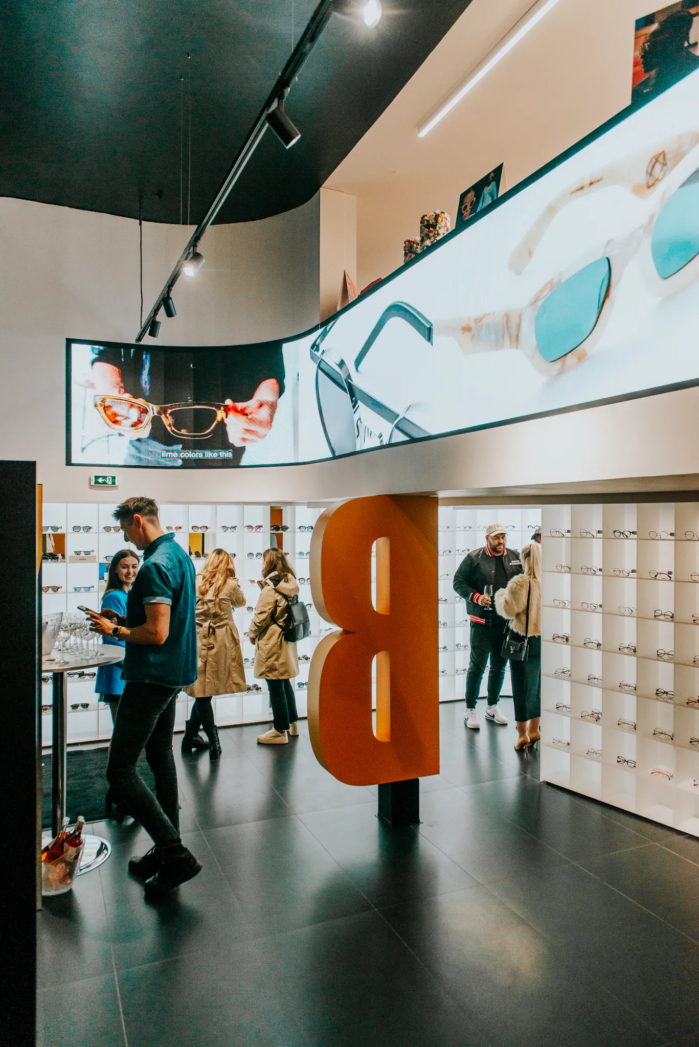 Indoor curved LED screen installed above the retail product area at Blink Optic Bucharest